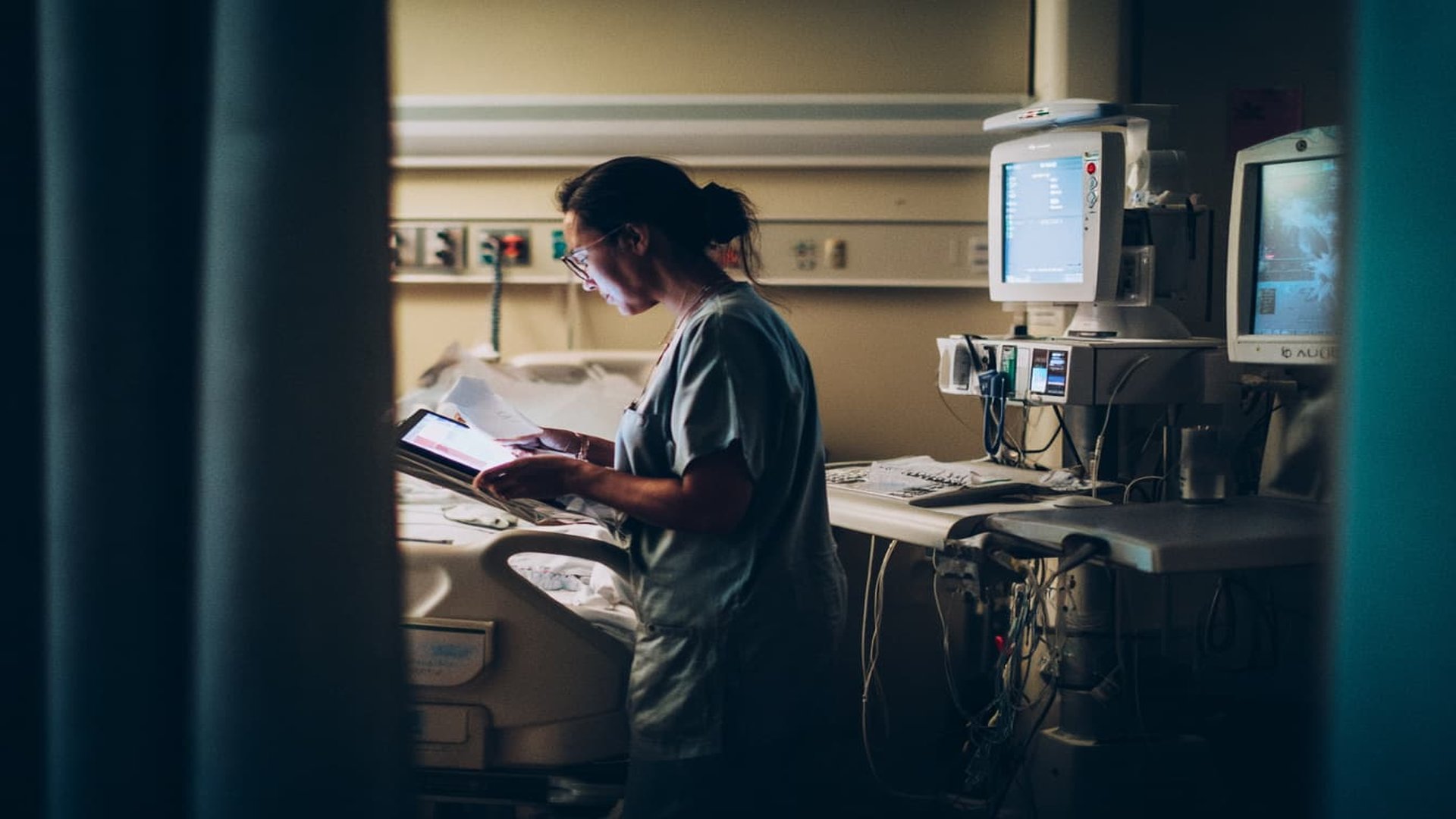 AI in Healthcare: Healthcare professional analyzing patient data with tablet in modern hospital environment